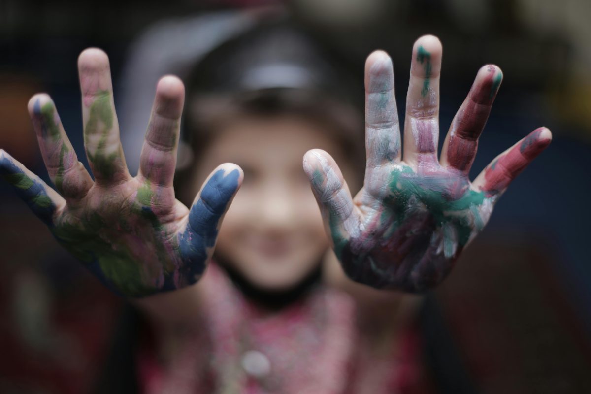 Close-up of a child's colorful painted hands, expressing joy and creativity.